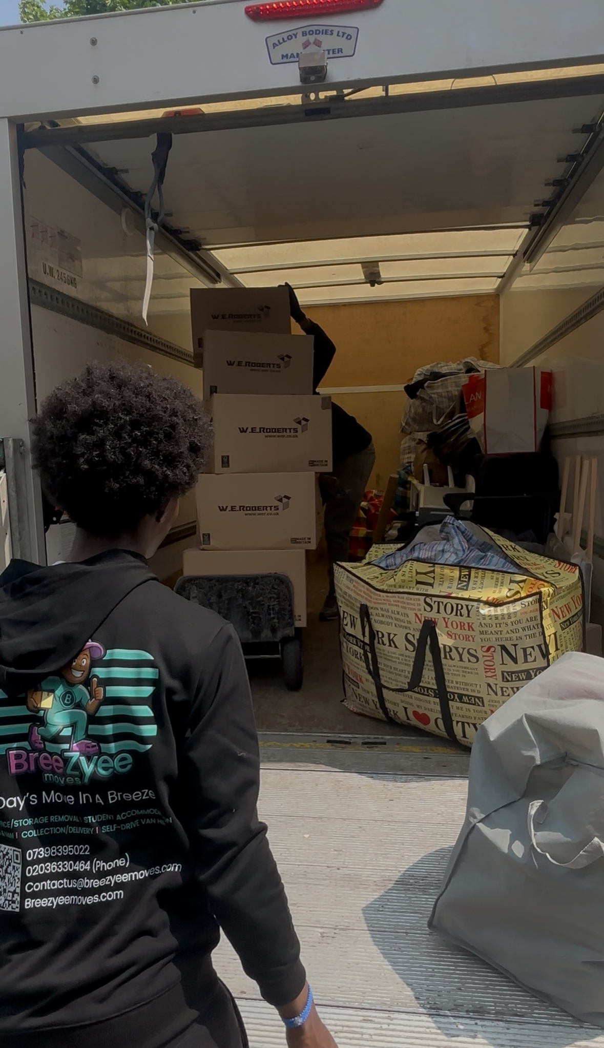 Team member loading van with clear Breezyee branding and contact details